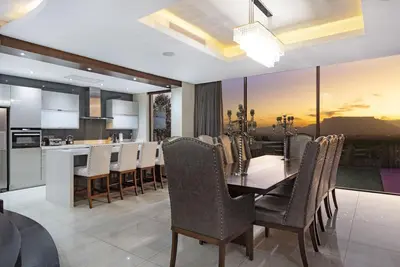 a kitchen and dining room with a table and chairs at Baronetcy Kings Villa in Plattekloof