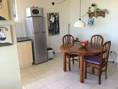a kitchen with a table and chairs and a refrigerator at Cozy Garden apartment with amazing view in Cape Town
