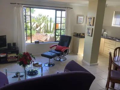 a living room with two chairs and a window at Cozy Garden apartment with amazing view in Cape Town