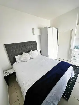 a bedroom with a large bed with a blue blanket at Beatrice Guesthouse in Cape Town