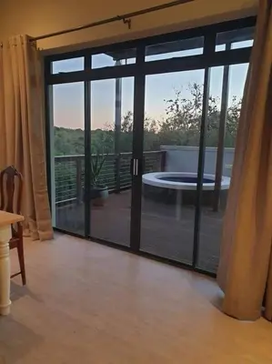 a room with sliding glass doors to a patio at 4 Bed Selfcatering River Tree House overlooking the Onrus river in Hermanus