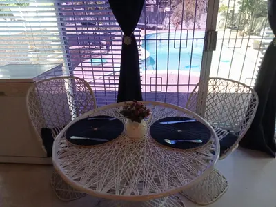 a white table and chairs with a vase on it at La Maison Kuilsrivier in Cape Town