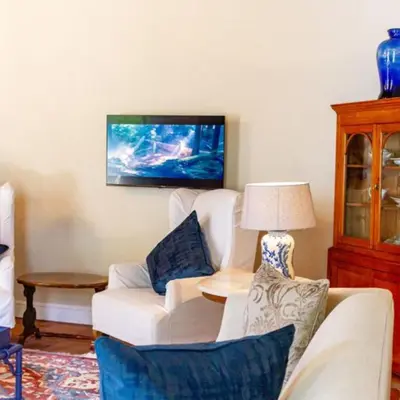 a living room with a white couch and a lamp at Plaisir Estate Accommodation in Simondium