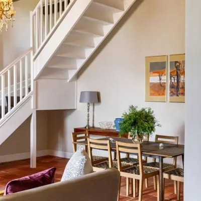 a living room with a table and a staircase at Plaisir Estate Accommodation in Simondium