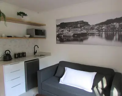 a living room with a couch and a sink at Lovely 1-bedroom rental with a pool in Cape Town