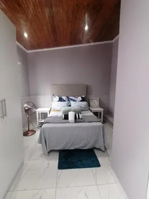 a bedroom with a bed and a wooden ceiling at Mila Lodge 1 in Cape Town