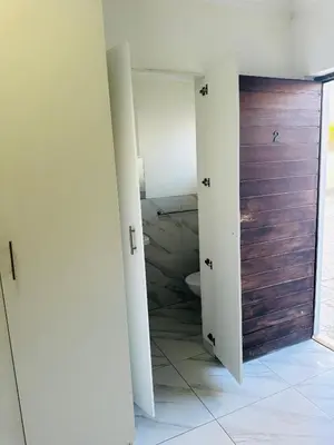a room with a bathroom with a toilet and a door at Mila Lodge 2 in Cape Town