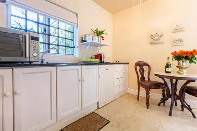 a kitchen with a table and a microwave at Devon Castle Forest Lodge in Stellenbosch
