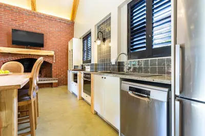 a kitchen with a brick wall and a table at Devon Castle Forest Lodge in Stellenbosch