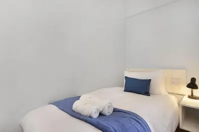 a bedroom with a white bed with towels on it at Pips Place 301 in Strand
