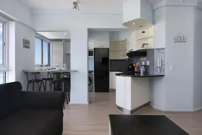 a kitchen and living room with a black refrigerator at Pips Place 301 in Strand