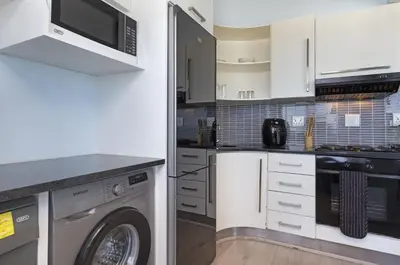 a kitchen with a washing machine and a washer at Pips Place 301 in Strand