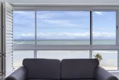 a couch sitting in front of a large window at Pips Place 301 in Strand