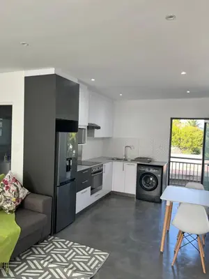 a kitchen with a couch and a table in a room at Sleepy Tides in Cape Town