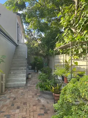 a patio with stairs and plants in front of a house at Sleepy Tides in Cape Town