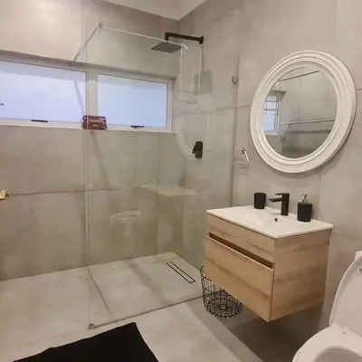 a bathroom with a sink and a shower with a mirror at 51 On Vlei in Cape Town