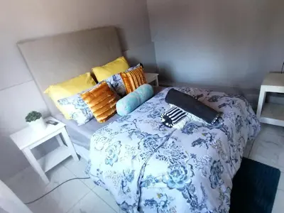 a bedroom with a blue and white bed and pillows at Mila Lodge 1 in Cape Town