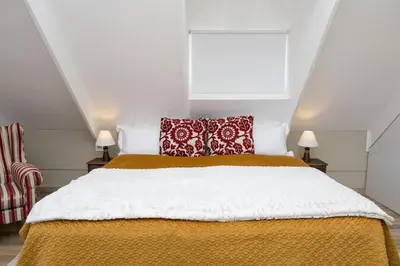 a bedroom with a bed with red and white pillows at Eden-Paradys in Stellenbosch