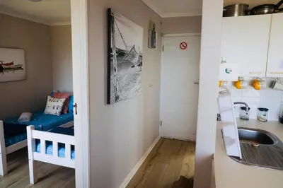 a small room with a sink and a bunk bed at Ocean Breeze @ Hermanus Beach Club in Hermanus