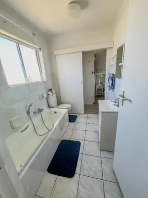 a bathroom with a tub and a sink and a toilet at Ocean Breeze @ Hermanus Beach Club in Hermanus