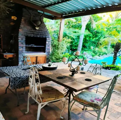 a table and chairs on a patio with a fireplace at Hidden Gem RUWARI in Cape Town