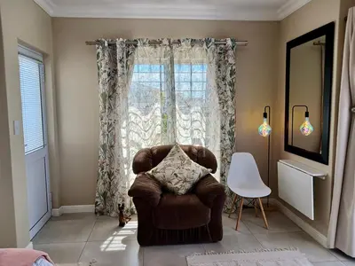 a living room with a chair and a window at 22's Company in Cape Town