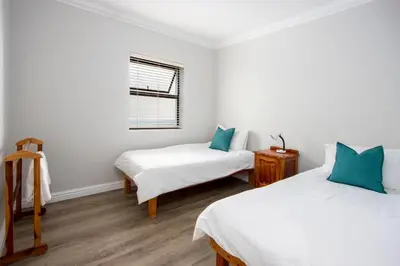 a room with two beds and a window at Wegbreek in Hermanus