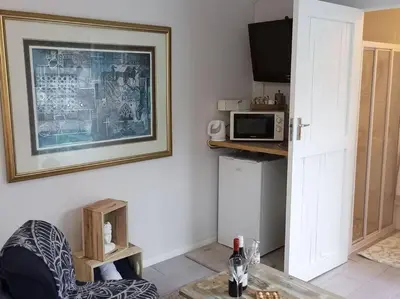 a living room with a table and a microwave at La Damon 1 in Paarl