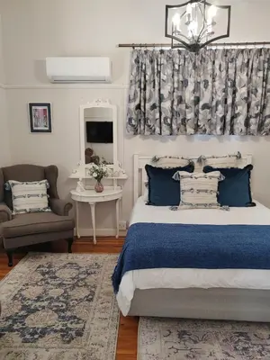a bedroom with a bed and a couch and a window at La Damon 2 in Paarl