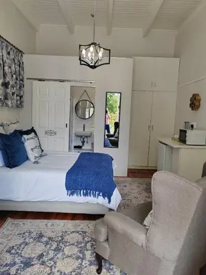 a bedroom with a bed and a couch and a chair at La Damon 2 in Paarl