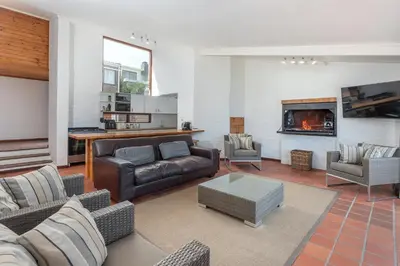a living room with a couch and a fireplace at The Atlantic in Onrus in Hermanus