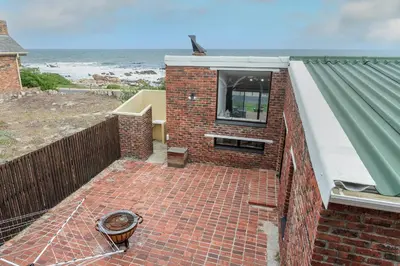 a brick house with a window and a brick floor at The Atlantic in Onrus in Hermanus