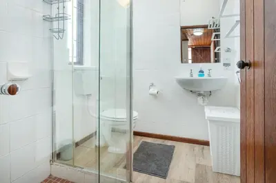 a bathroom with a glass shower and a sink at The Atlantic in Onrus in Hermanus