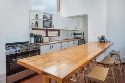 a kitchen with a wooden table and a stove at The Atlantic in Onrus in Hermanus