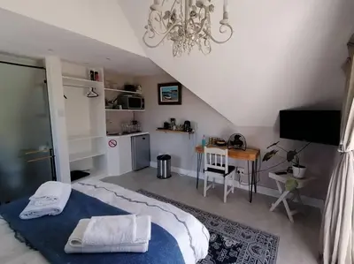 a bedroom with a bed and a desk in it at Cape Dutch Flair Business unit in Cape Town
