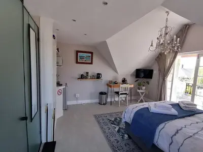 a bedroom with a bed and a table in it at Cape Dutch Flair Business unit in Cape Town