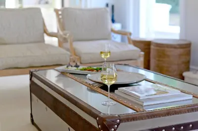 a living room with a glass table with two glasses of wine at Farm Lorraine Lake Cottage, Loft Cottage and Garden Cottage in Franschhoek