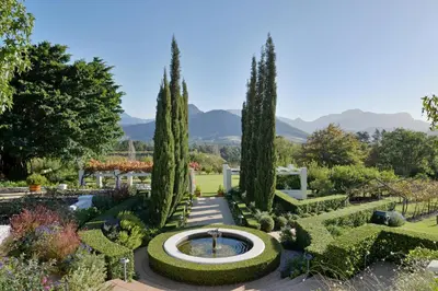 a garden with a fountain and trees at Farm Lorraine Lake Cottage, Loft Cottage and Garden Cottage in Franschhoek