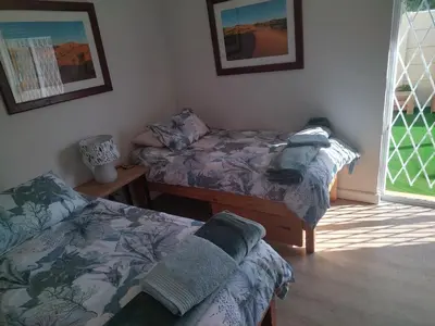 a room with two beds and a window with at Worcester Garden Cottage in Worcester