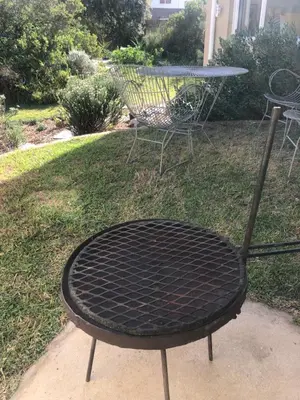 a black iron table and chair in a yard at The Annex in Pringle Bay