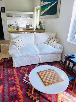 a living room with a couch and chessboard on a table at The Annex in Pringle Bay