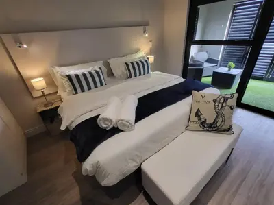 a large bed with white sheets and pillows in a bedroom at *Self-Check in - Whale Watching Paradise -Central* in Hermanus