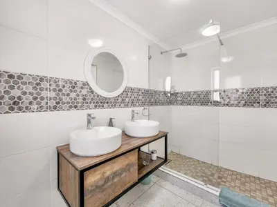 a bathroom with two sinks and a mirror at Tranquil Family Escape: Pool Balcony in Cape Town