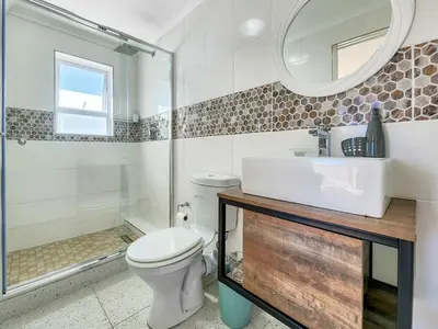 a bathroom with a toilet and a sink and a shower at Tranquil Family Escape: Pool Balcony in Cape Town