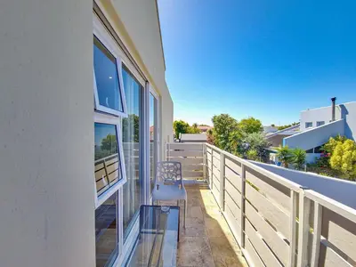 a balcony of a house with a chair on it at Tranquil Family Escape: Pool Balcony in Cape Town