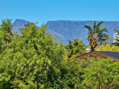 a house with trees and mountains in the background at Tranquil Family Escape: Pool Balcony in Cape Town