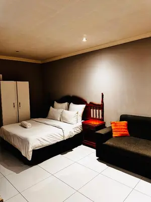 a bedroom with a bed and a couch at Mila Lodge 1 in Cape Town