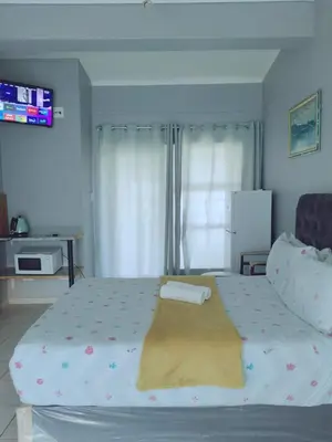 a bedroom with a bed with a blanket on it at Gardenia Guesthouse in Cape Town