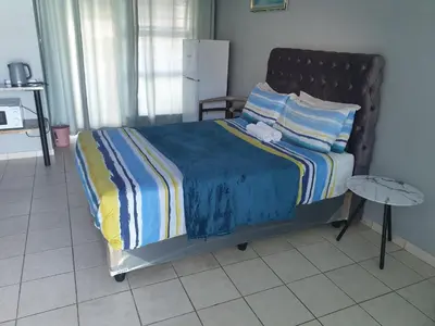 a bedroom with a bed with a teddy bear on it at Gardenia Guesthouse in Cape Town