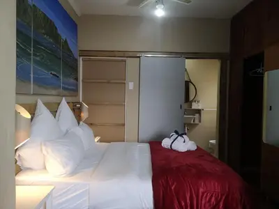 a bedroom with a white bed with towels on it at Coastal Cozy 1 in Cape Town